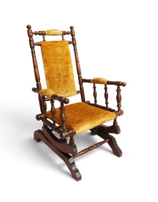 an old rocking chair with a yellow upholstered seat on a white background