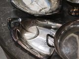 a table with a lot of silver plates and bowls on it