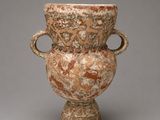 un vase posé sur un socle, sur une surface grise