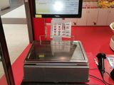 un ordinateur et un clavier posés sur une table rouge dans un magasin