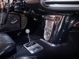 dashboard of a classic car with black leather seats and chrome trims