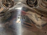 a silver plate with a face on it on a table