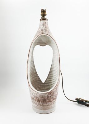 a white vase shaped like a heart with a cord attached to it