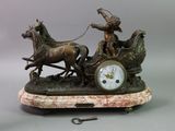 a statue of a man on a horse drawn carriage with a clock