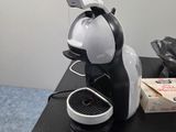 a coffee machine sitting on a table next to a cup of coffee