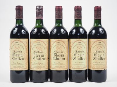 quatre bouteilles de vin sont alignées sur une surface blanche