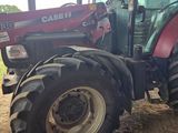 a red tractor that is parked in the dirt
