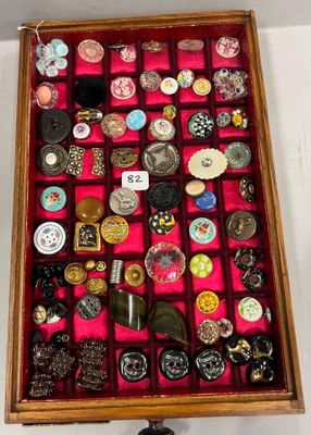 une boîte en bois remplie d'une multitude de boutons et de broches
