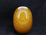 une image représentant un vase jaune sur fond noir