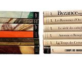 several books stacked on top of each other on a white surface