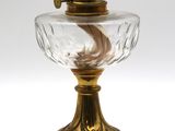 une lampe à l'ancienne avec un abat-jour en verre posé sur un socle en bois