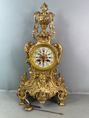 a gold clock that is sitting on the floor