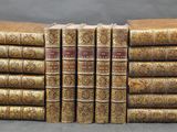 six old books stacked on top of each other on a table
