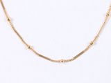 a close up of a gold necklace on a white background