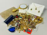 a pile of gold jewelry on a table next to a mirror