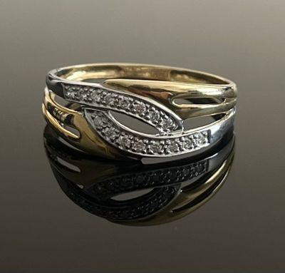 un gros plan sur une bague en or et en argent sertie de diamants