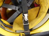 a person holding a yellow helmet with a black strap