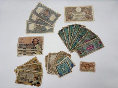 plusieurs types différents de billets de banque disposés sur une surface blanche