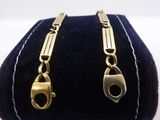 a close up of a pair of gold earrings on a blue velvet bag
