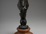 a bronze statue of a dog on a wooden base