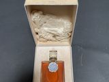 an open box with a small bottle of perfume inside of it