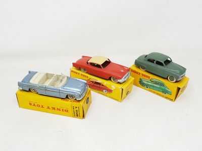 three toy cars are sitting on top of boxes on a white surface