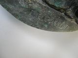 une statue en bronze représentant un homme tenant un couteau