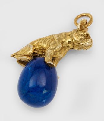 un gros plan d'un pendentif en or et lapis-lazuli orné d'une pierre bleue
