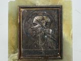 une image d'un homme barbu sur une plaque de marbre