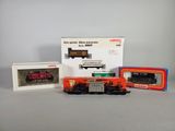 trois trains miniatures assis l'un à côté de l'autre sur une table