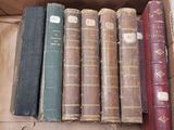de nombreux livres anciens dans une boîte posée sur une table