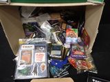 a cardboard box full of cards and games on the floor