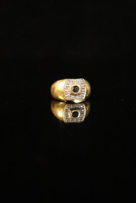 an image of a gold ring with diamonds on a black surface