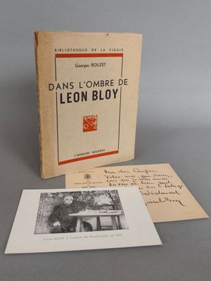 un vieux livre posé sur une table à côté d'une feuille de papier