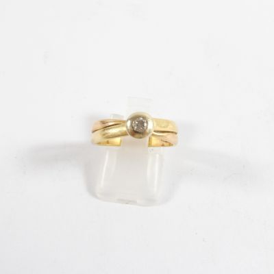 gros plan d'une bague en or surmontée d'un diamant
