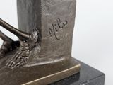a bronze statue of a bird on top of a book