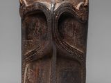 a close up of a wooden vase with a snake on it