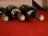 several bottles of wine are lined up on a red table