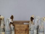 four bottles of champagne sitting on a table next to a box of wine