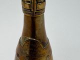 a gold bottle that is sitting on a white surface