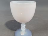 a white glass cup sitting on top of a table