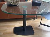 une table en verre avec un plateau en verre et un piètement en métal