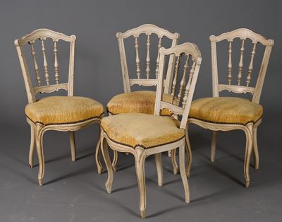 quatre chaises avec des coussins rembourrés jaunes et des pieds en bois