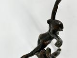statue of a monkey on a branch with a ball in its hand