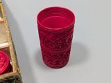 a red cup sitting on a table next to a wooden box