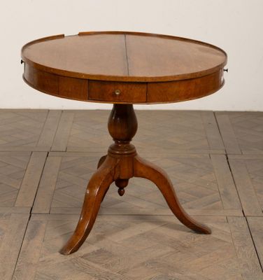 une table ronde avec un plateau en bois posée sur un parquet