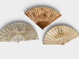 trois éventails chinois sont posés sur une surface blanche