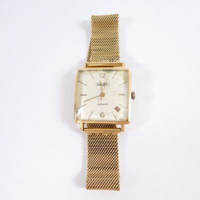 an image of a gold wrist watch on a white surface