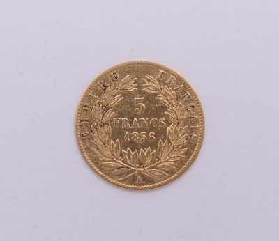 gros plan d'une pièce d'or sur une surface blanche