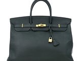 un sac à main en cuir noir muni d'un fermoir doré sur la poignée